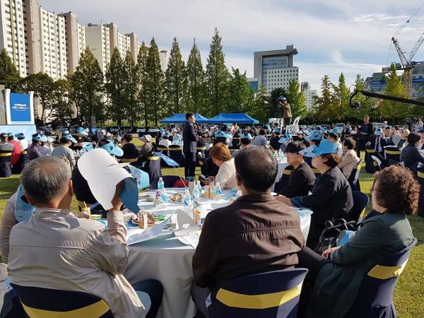 야외에 설치된 원탁에서 다수가 참여하는 토론 현장